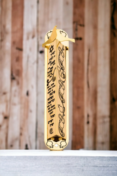 Un boîtier de mézouza décoré de grenades et de la bénédiction de la maison, recouvert d'or 24 carats 